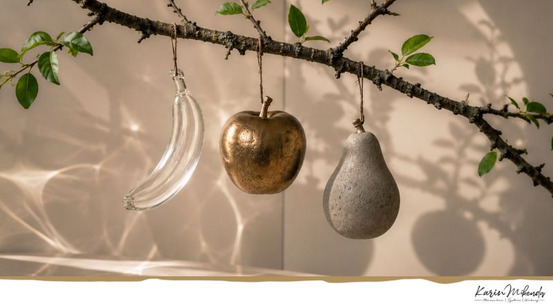 Gläserne Früchte hängen im warmen Licht an einem Ast